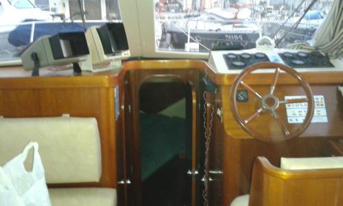 a wooden boat with a steering wheel on a boat at leyliley in Portosin