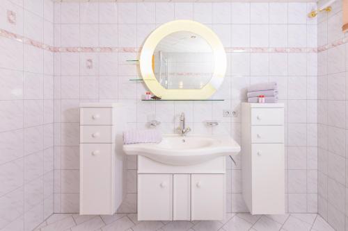 a white bathroom with a sink and a mirror at Ferienwohnung Sonja in Elmen