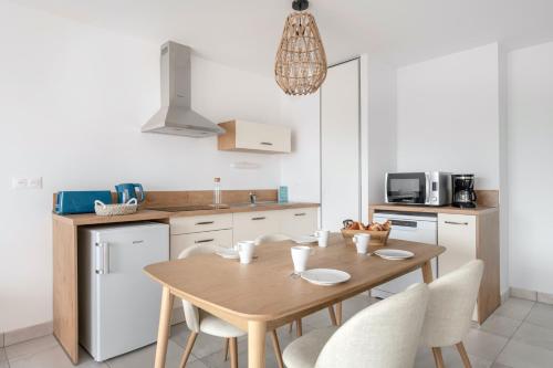 - une cuisine avec une table et des chaises en bois dans l'établissement Appartement pour 4 avec vue mer à Pléneuf, à Pléneuf-Val-André