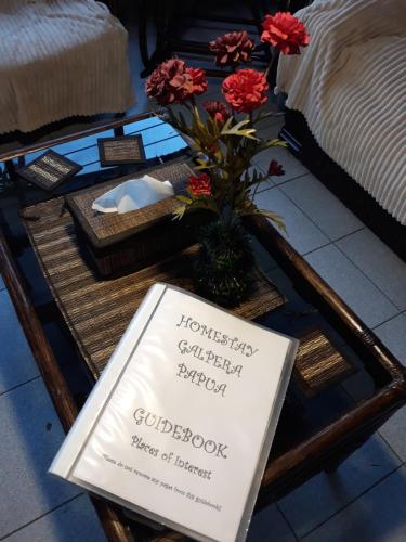 a sign on a coffee table with flowers on it at Homestay Galpera Papua in Jayapura