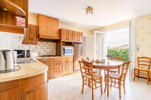 une cuisine avec une table et des chaises et une fenêtre dans l'établissement Maison de vacances à Saint Hilaire de Riez, à Saint-Hilaire-de-Riez