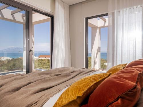 a bedroom with a bed and large glass windows at ELYSIAN VILLA in Amoudi