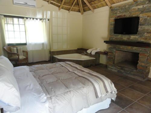 sypialnia z łóżkiem, kominkiem i wanną w obiekcie Solares de la Laguna w mieście Santa Fe