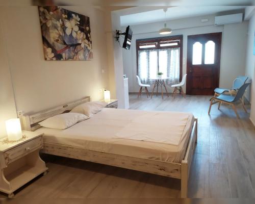 1 dormitorio con 1 cama y sala de estar con sillas en Elias Apartments, en Nydri