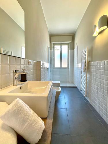 a white bathroom with a sink and a tub at Maison A in La Spezia