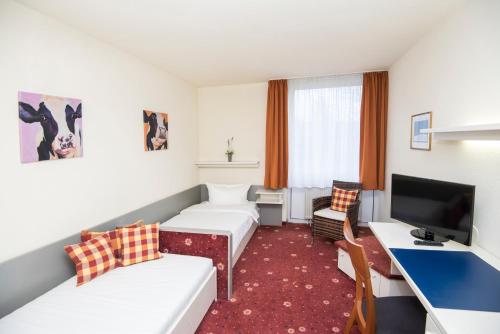 a hotel room with a couch and a desk at Akzent Hotel Höhenblick in Mühlhausen im Täle