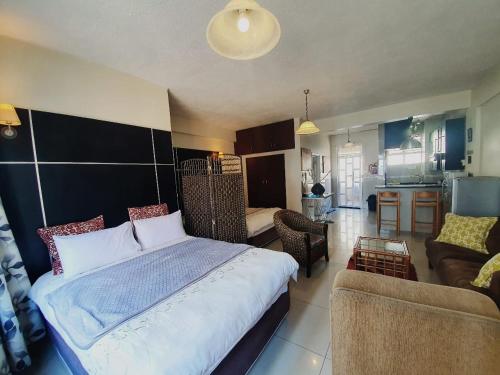 a bedroom with a large bed and a living room at Marlborough Durban Beachfront South Beach luxury Holiday Apartments on Marine Parade! in Durban