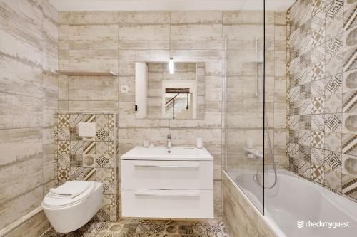 La salle de bains est pourvue de toilettes, d'un lavabo et d'une baignoire. dans l'établissement CMG - Place de le République / Meslay, à Paris