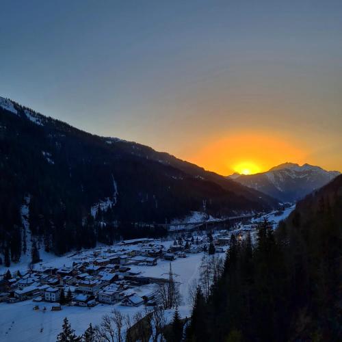 a view of a village in the snow at sunset at der klostertalerhof in Klösterle am Arlberg