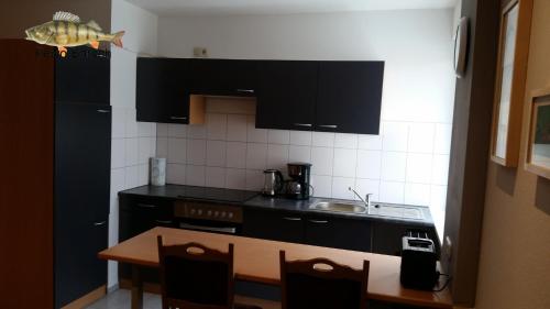 a kitchen with black cabinets and a wooden table at Fewo Helmstedt in Helmstedt
