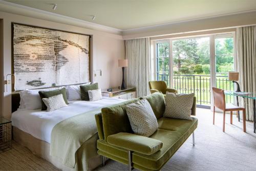 sypialnia z dużym łóżkiem i zieloną kanapą w obiekcie The Grove w mieście Chandler's Cross