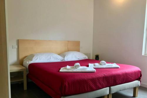 a bedroom with a red bed with two towels on it at Rifugio del Gran Sasso in Assergi