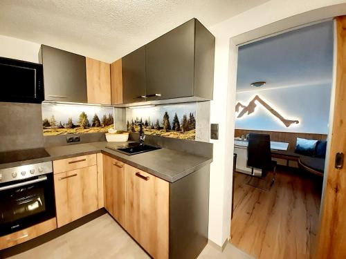 eine Küche mit Holzschränken und einem großen Fenster in der Unterkunft Apart ZIRMZEIT in Huben
