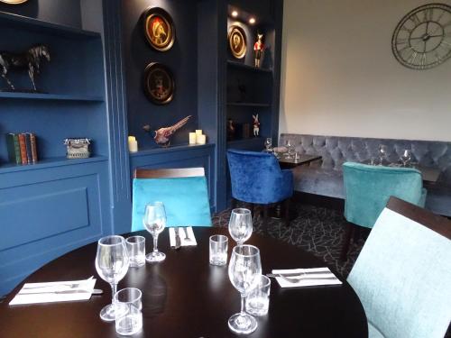 a dining room with a table with wine glasses at The Beeches Hotel & Leisure Club in Nottingham