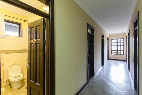 a bathroom with a toilet and a hallway at Airport Planet Lodge in Kingori