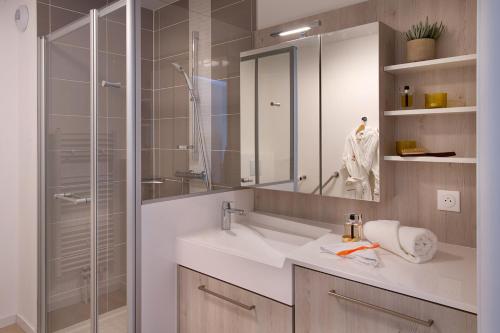 a bathroom with a sink and a glass shower at DOMITYS - Olympe in Marcq-en-Baroeul