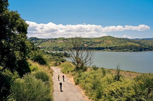 two people walking down a dirt road next to a lake at TUI MAGIC LIFE Calabria - All Inclusive in Pizzo