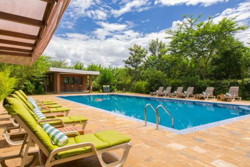 a swimming pool with chaise lounge chairs next to a swimming pool at Airport Planet Lodge in Kingori