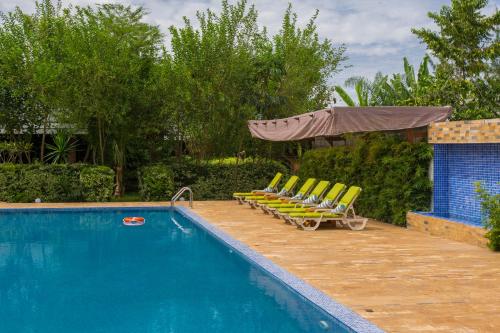 a swimming pool with lounge chairs and an umbrella at Airport Planet Lodge in Kingori
