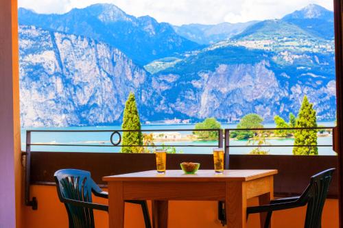 a table and chairs on a balcony with a view of mountains at Hotel Villa Isabella in Brenzone sul Garda