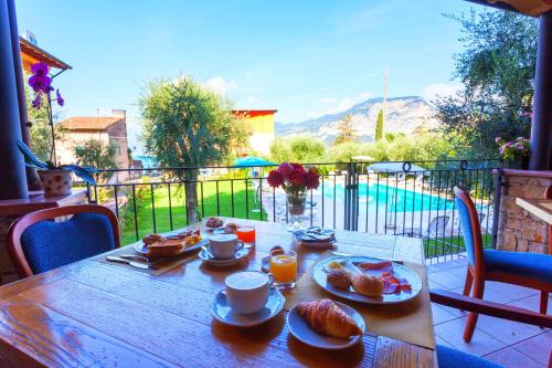 a wooden table with food on top of a balcony at Hotel Villa Isabella in Brenzone sul Garda
