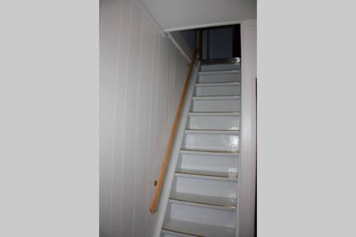a staircase in a room with white tiles at House with a warm soul in North Iceland in Siglufjörður