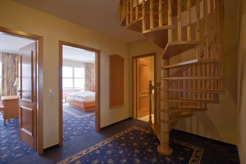 a hallway with a spiral staircase and a bedroom at Vitalhotel Sonneneck in Hohegeiß