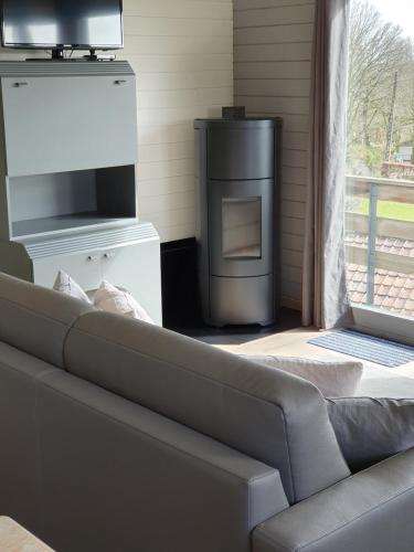 a living room with a couch and a wood stove at Chalet de la Sablière in Amougies