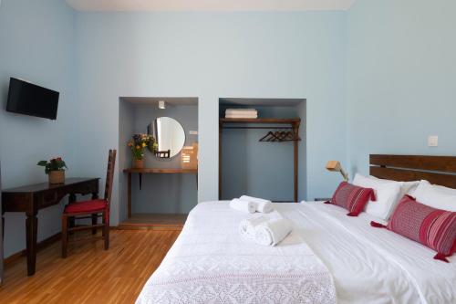 a bedroom with a bed and a desk and a mirror at Kalamata Art Rooms in Kalamata