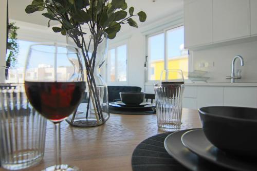 una mesa con una copa de vino y dos vasos de agua en Phaedrus Living: Seaside Modern Flat Lighthouse 63, en Pafos