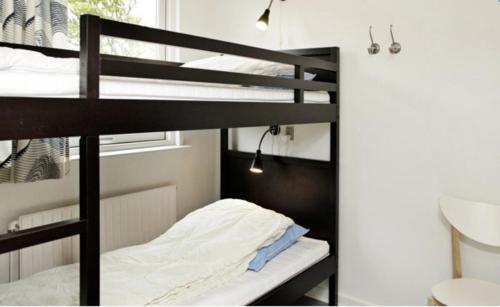 a bunk bed in a room with a bunk bed in a room at Charming On the beach Apartment in Brenderup