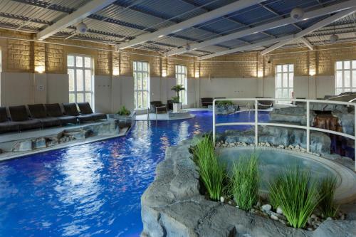 une grande piscine intérieure d'eau bleue dans un bâtiment dans l'établissement Slaley Hall Hotel, Spa & Golf Resort, à Slaley