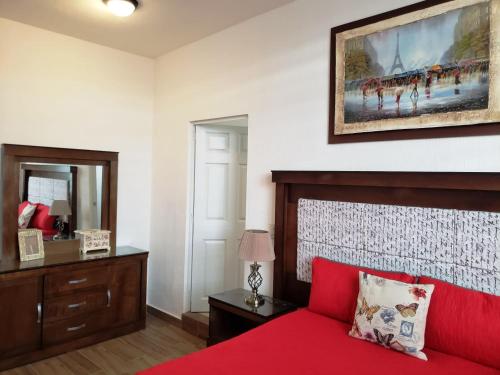 - une chambre avec un lit rouge et un tableau mural dans l'établissement Casa con Alberca a solo 5 minutos de Playas de Nuevo Vallarta RBL33, à Nuevo Vallarta