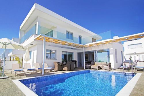 a villa with a swimming pool in front of a house at Villa Napa View in Ayia Napa