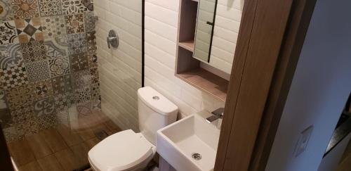 a bathroom with a toilet and a sink and a mirror at Studio amplio y comodo en Equipetrol in Santa Cruz de la Sierra