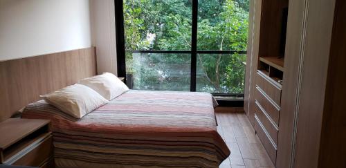 a bedroom with a bed and a large window at Studio amplio y comodo en Equipetrol in Santa Cruz de la Sierra