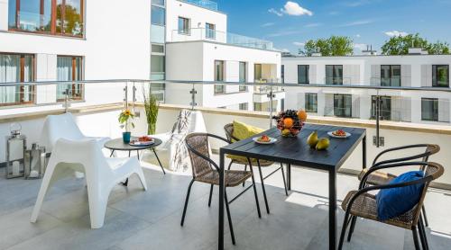 een balkon met een tafel en stoelen in een gebouw bij Finale Apartments in Krakau