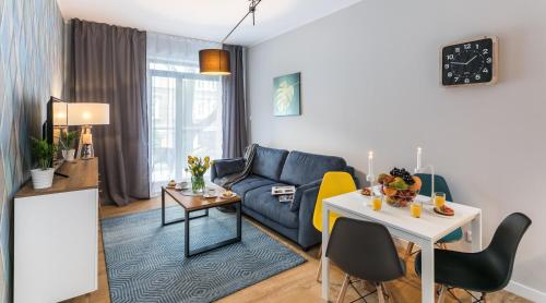 een woonkamer met een blauwe bank en een tafel bij Finale Apartments in Krakau