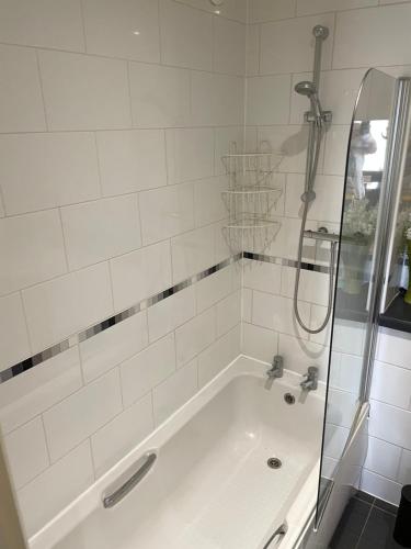 a bathroom with a bath tub with a shower at City Central Apartment in Coventry
