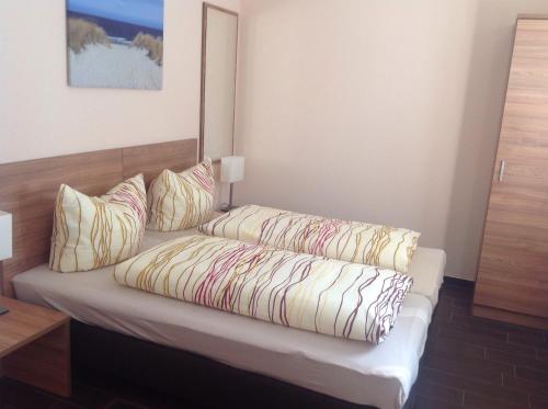 a room with a bed with pillows on it at Pension an der Werft in Rostock