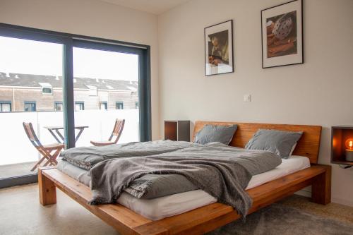 - une chambre avec un lit en bois et une grande fenêtre dans l'établissement Lakeside Ermatingen, à Ermatingen