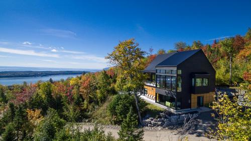 una casa en una colina con vistas al agua en Le Secret de Charlevoix, en Les Éboulements