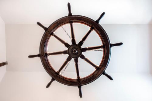 a wooden steering wheel hanging on a wall at The Ferry Boat Inn in North Fambridge