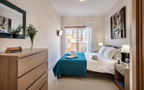 une chambre avec un lit avec une couverture bleue dans l'établissement Penthouse Apartment Royal Cabanas Resort, à Cabanas de Tavira