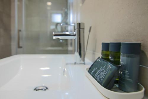 un lavabo con un recipiente de cepillos de dientes en Phaedrus Living Seaside Junior Suite Lighthouse 63, en Pafos