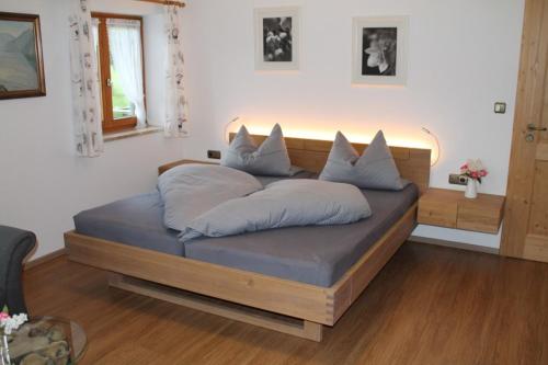 a bed with pillows on it in a room at Pension Neuhausen in Schönau am Königssee