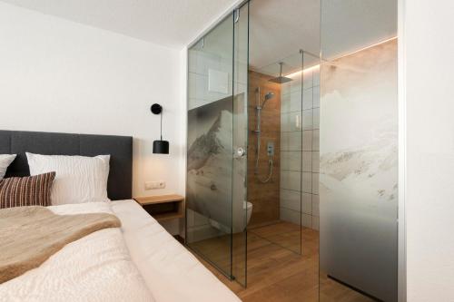 a bedroom with a glass shower and a bed at Moose Lodge in Sankt Anton am Arlberg