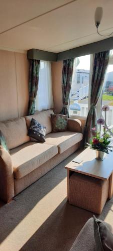 a living room with a couch and a table at Church Farm Haven Holiday Park in Pagham