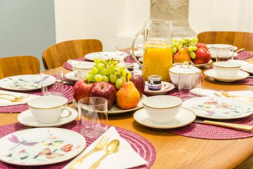 a table with plates and cups and fruit on it at Ca' Monteggia Guest House in Milan