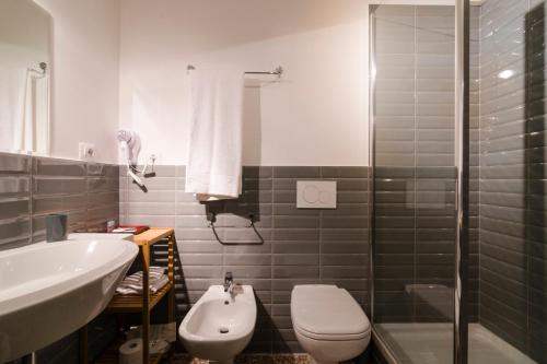 a bathroom with a sink and a toilet and a shower at Ca' Monteggia Guest House in Milan
